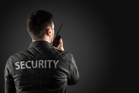 The man, security, is holding a walkie-talkie. The concept of protection, protection of information, bodyguard.の写真素材