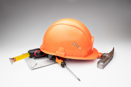 White construction helmet, tape measure, hammer, screwdriver on a light background. Concept architecture, construction, engineering, design, repair. Copy space.の写真素材