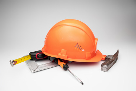 White construction helmet, tape measure, hammer, screwdriver on a light background. Concept architecture, construction, engineering, design, repair. Copy space.の写真素材