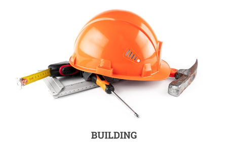White construction helmet, tape measure, hammer, screwdriver on a light background. Inscription construction. Concept architecture, construction, engineering, design, repair.の写真素材