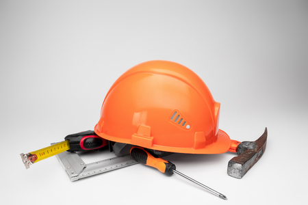 White construction helmet, tape measure, hammer, screwdriver on a light background. Concept architecture, construction, engineering, design, repair. Copy space.の写真素材
