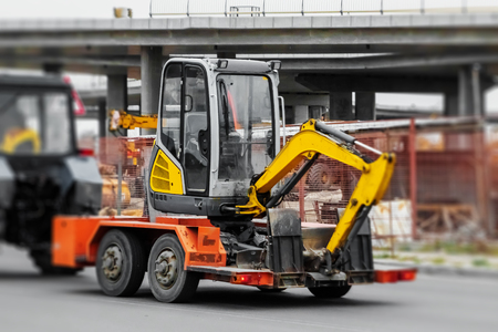 Transportation of construction equipment, a small excavator on a trailer. Delivery, transportation.の写真素材