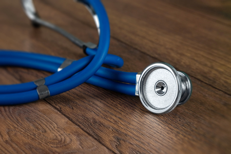 Silver stethoscope on the table, close-up. The concept of medicine, a doctor's appointment, health care.の写真素材