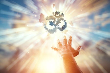 Hand closeup on the background of the symbol of Hinduism, prayer. The concept of religion, hope, faith, a symbol of freedom.の写真素材