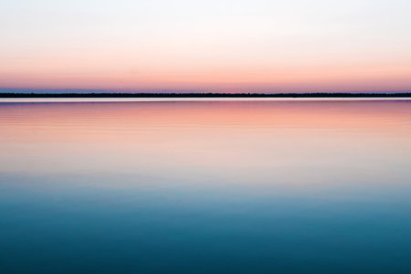 Beautiful, red dawn on the lake. The rays of the sun through the fog. The blue sky over the lake,...