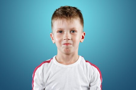 little boy with his hands up smiling on a blue background