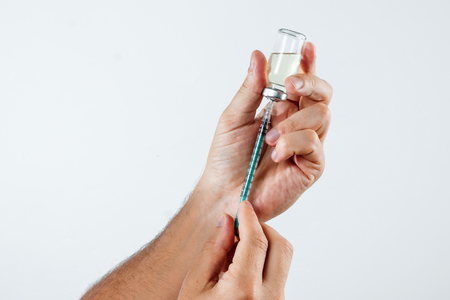 Close-up in a man's hand ampoule with medication and syringe for insulin. The concept of taking medication, treatment, put an injection.の写真素材