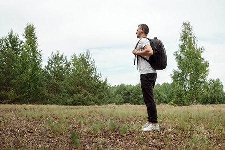 Portrait of a young man, a wanderer with a backpack. Goes on the road with a copy space, a happy...