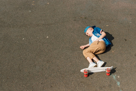 A small city boy and a skateboard. A young guy is riding in a park on a skateboard. City Style. City...
