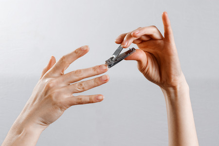 female hands cut off nails on a white background, isolate.の写真素材