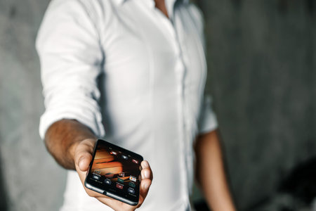 Close-up, the hand of a man with a phone on the background of concrete. Businessman.