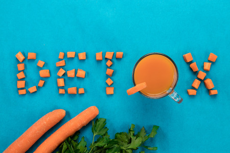 Inscription detox, top view, carrot juice in a glass on a blue background.の写真素材