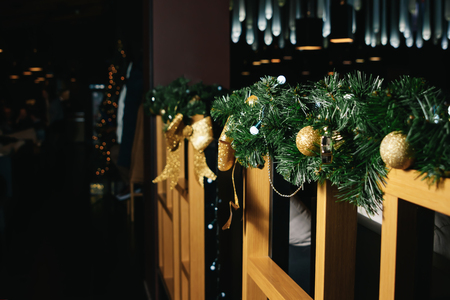 Christmas decorations on a wooden fence, branches of a green Christmas tree, golden balls. Happy New Year and Merry Christmas.の写真素材