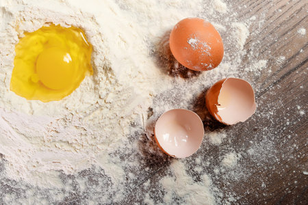The top view of an egg, beaten into flour, cooking dough against the background of a wooden table....