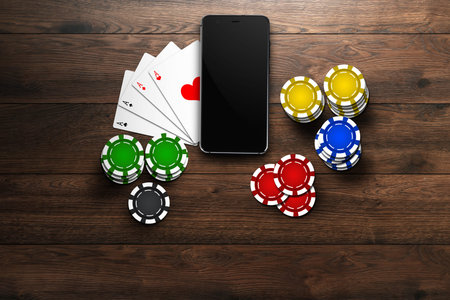 Online casino, mobile casino, top view of a mobile phone, chips cards on a wooden background....