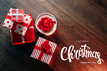 The inscription of Merry Christmas and Happy New Year, decorations and gifts on a wooden brown table. Christmas card, holiday background. Mixed media.の写真素材
