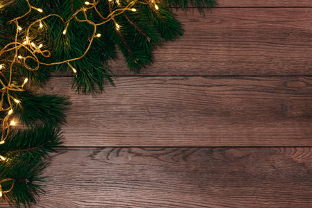 Frame from the pine branches and Christmas decorations on an old wooden table. Holidays Christmas background. Space for text or design. Top view.