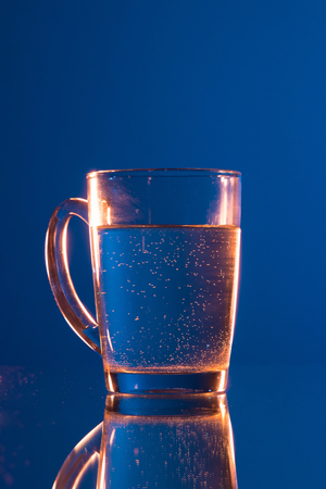 Water in glass, on dark blue backgroundの写真素材