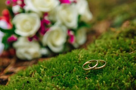 Wedding rings with bridal bouquet lying on the morning of the bride.の写真素材