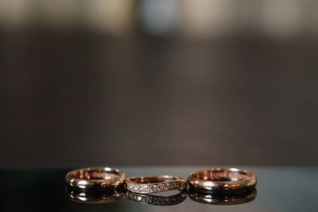 Gold wedding rings lie on a wooden tableの写真素材