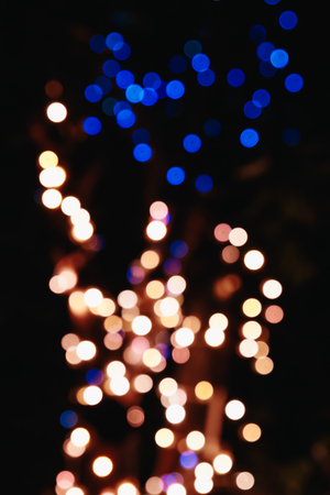 Blurred Christmas lights on a black background, bokeh. Light bokeh abstract. The concept of the new year 2018, holidays, vacation.の写真素材