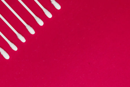 Hygienic, cotton buds on a red background. The concept of hygiene, cleanliness.