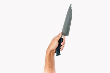 A man's hand holds a knife isolated on a white background.