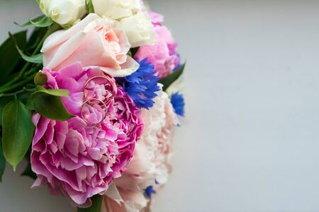 Gold wedding rings on the wedding bouquet of the brideの写真素材