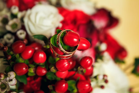 Golden wedding rings on the background of a wedding bouquet of red roses