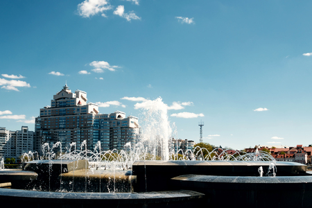 A modern fountain in the city park on the summer playground. Cascade system of urban fountains in the main square on a sunny summer dayの写真素材