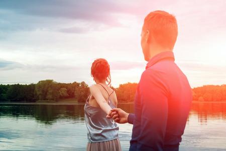 couple in love walking along the waterfront with her dog.の写真素材