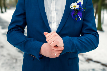 A man buttoning a blue jacket flower on chestの写真素材