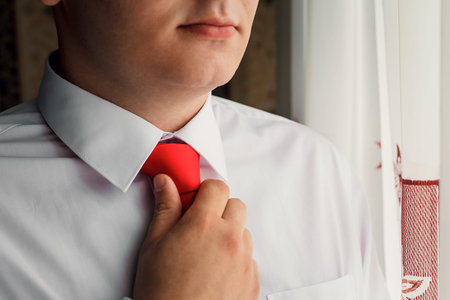 detail of a young business man in a suit and tie on green backgroundの写真素材