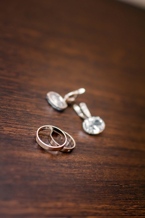 Gold wedding rings lie on a wooden tableの写真素材