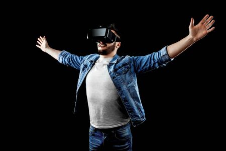 Portrait of a man in virtual reality glasses, vr, against a dark background. The concept of the future is here, applications complement reality, the virtual reality interface. Copy space.の写真素材