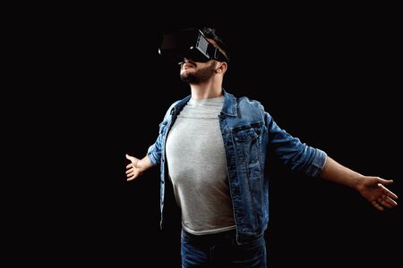 Portrait of a man in virtual reality glasses, vr, against a dark background. The concept of the future is here, applications complement reality, the virtual reality interface. Copy space.の写真素材