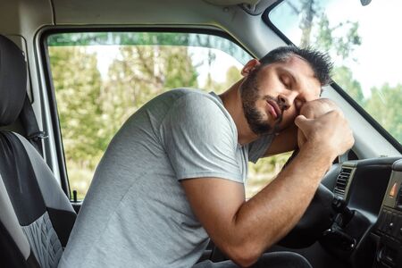 The man, the driver of the car fell asleep at the wheel during the trip. Emergency, accident, violation of rights.の写真素材