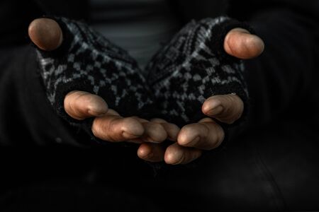 hands close up poor old man or beggar begging you for help sitting at dirty slum. Concept for poverty or hunger people,human Rights,donate and charityの写真素材