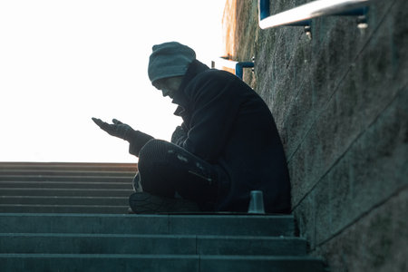 A man, homeless, a person asks for alms on the street with a Help sign. concept of homelessness,...