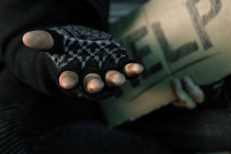 hands close up poor old man or beggar begging you for help sitting at dirty slum. Concept for poverty or hunger people,human Rights,donate and charityの写真素材