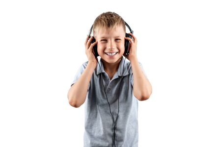White smiling boy listens to music in big headphones Isolated on a white background. Musician, the future of the child, music loverの写真素材