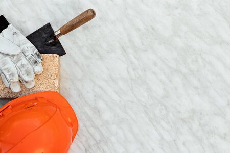 Brick trowel a construction helmet and gloves lie on a light background, top view. flat lay copy space. Concept construction building repairの写真素材