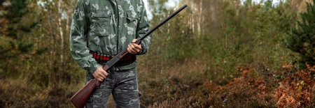 Hunter man in camouflage with a gun during the hunt in search of wild birds or game on the...