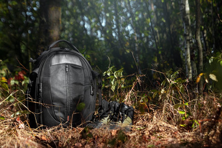 Camping backpack and boots on a background of summer nature. Trekking and camping adventures,...