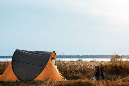 Camping tent green in the background of nature and lake. The concept of travel, tourism, campingの写真素材