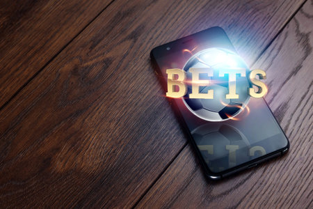 Smartphone on a wooden table. Golden inscription Bets. Bets, sports betting, bookmaker. Mixed media.