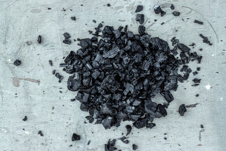 A pile of dark coal on a white background, coal mining, fossil fuel, environmental pollution