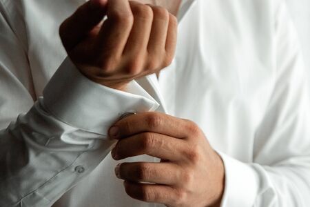 Hands of a businessman, closeup, button sleeves on a shirtの写真素材