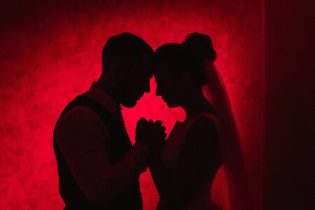bride and groom on a red background, the concept of family relations, wedding paraphernaliaの写真素材