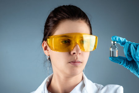 The girl is a doctor, scientist, laboratory assistant holding a bottle with a vaccine, medical...